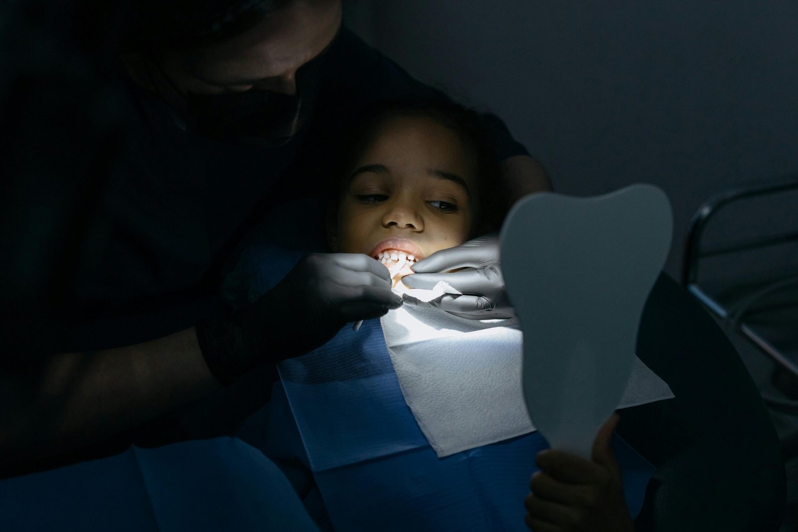 Services A child receives a dental checkup at a clinic, highlighting oral health care.